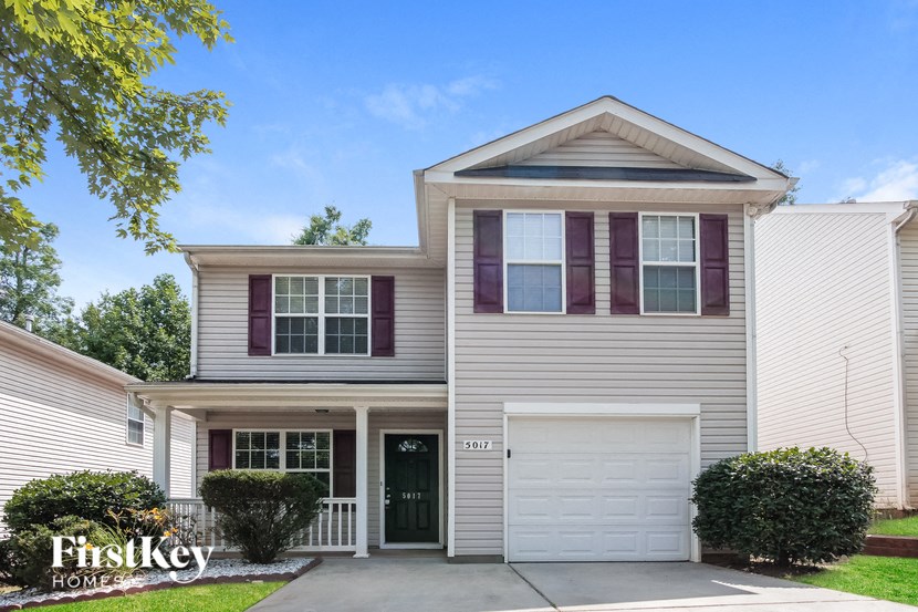 a white house with purple shutters and a driveway