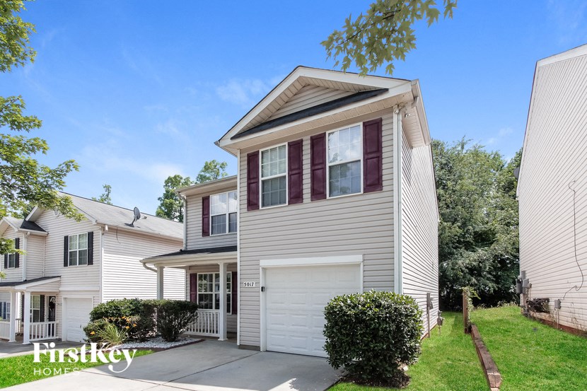 a white house with a white garage door and a lawn