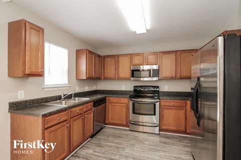 a kitchen with wooden cabinets and stainless steel appliances