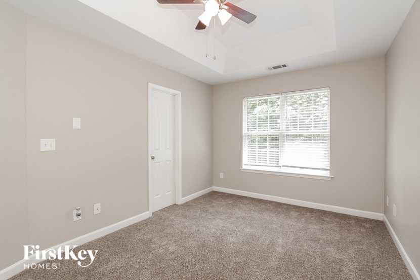 a bedroom with carpet and a ceiling fan