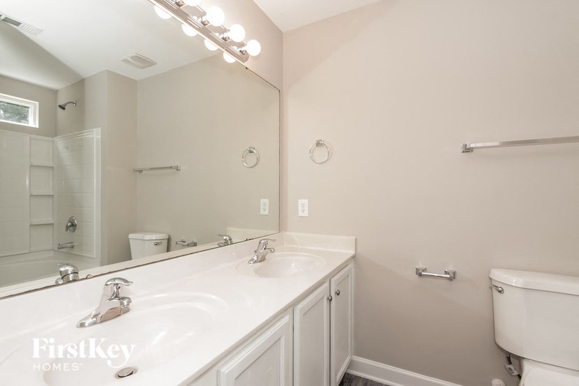 a white bathroom with a large mirror and a white sink