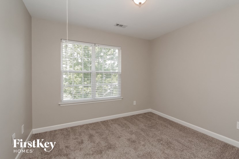 a bedroom with carpet and a large window