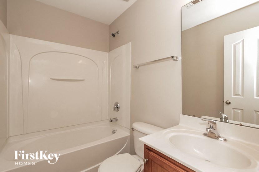 a bathroom with a sink and a tub and a mirror