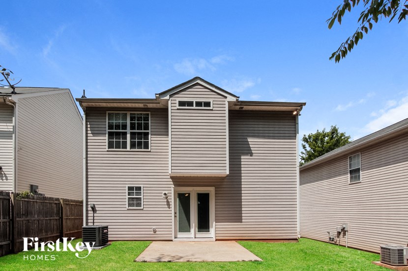a gray house with a yard and a blue sky