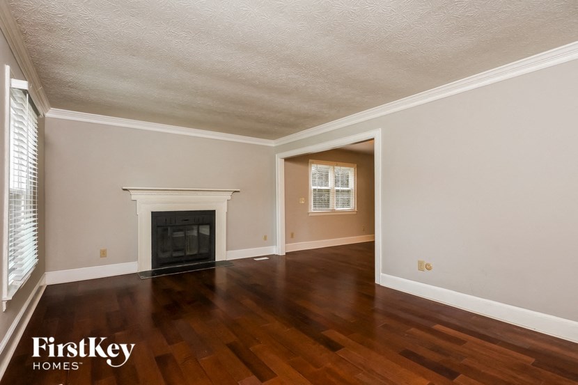 the living room of a house with wood floors and a fireplace