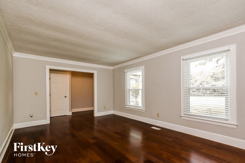 an empty living room with wood floors and a door and window