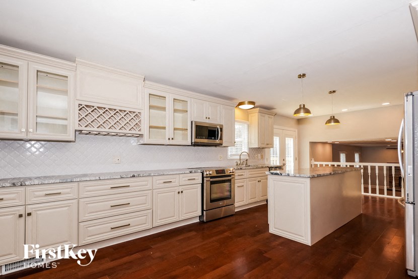 a large kitchen with white cabinets and stainless steel appliances