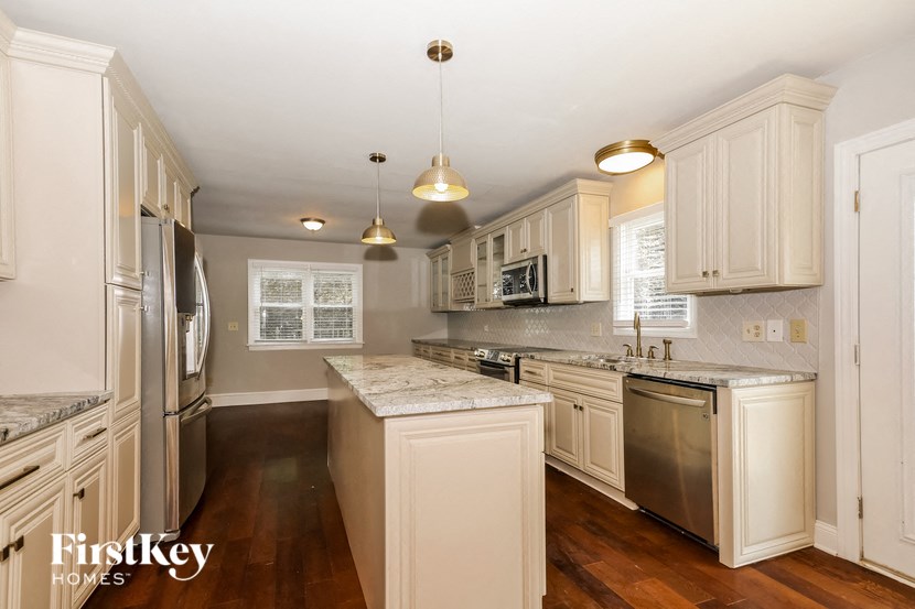 a kitchen with white cabinets and stainless steel appliances