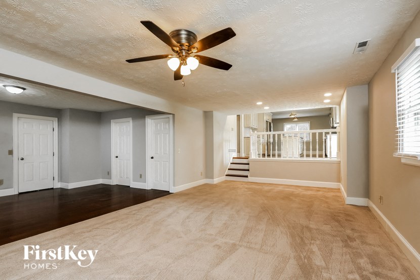 an empty living room with a ceiling fan