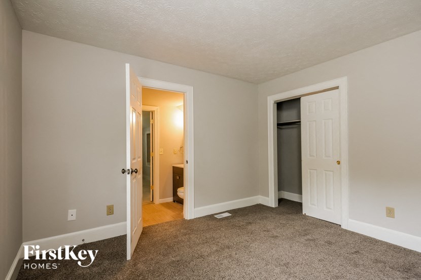 the living room of an empty house with the door open