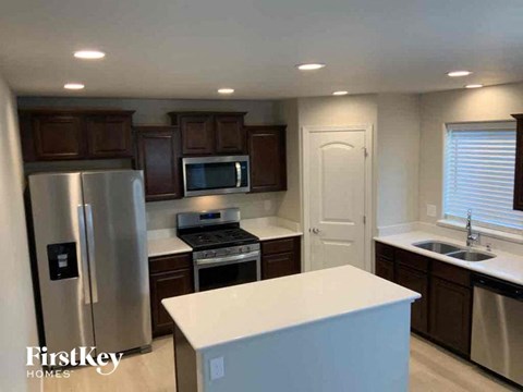 an updated kitchen with stainless steel appliances and white counter tops
