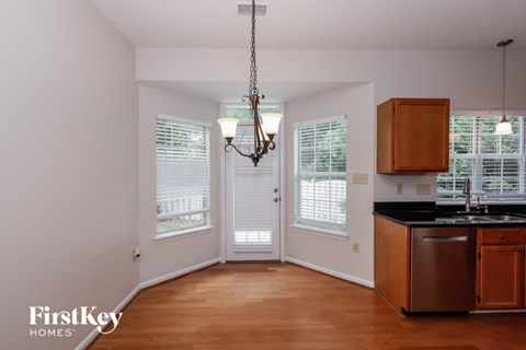 A well-lit kitchen with wooden cabinets and a chandelier.
