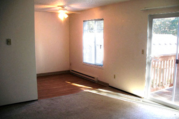 an empty living room with a door and a window
