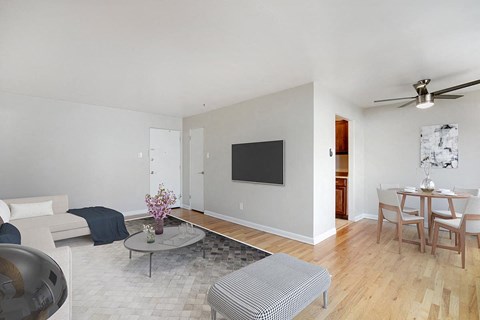 a living room and dining room with a table and a television