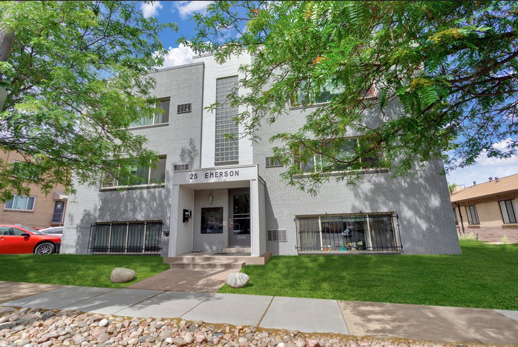 the front of a building with a sidewalk and grass