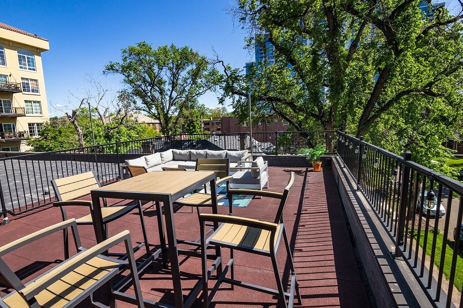 a patio with tables and chairs on a balcony