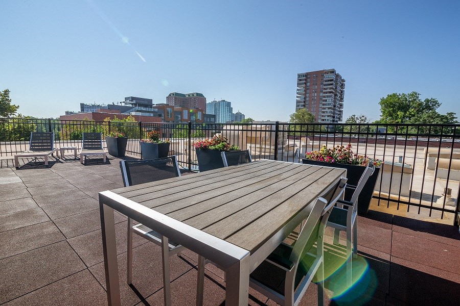 a patio with a table and chairs on a balcony with a view of the city