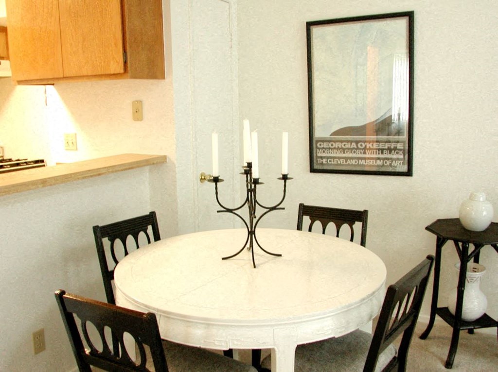 a dining room with a white table and chairs
