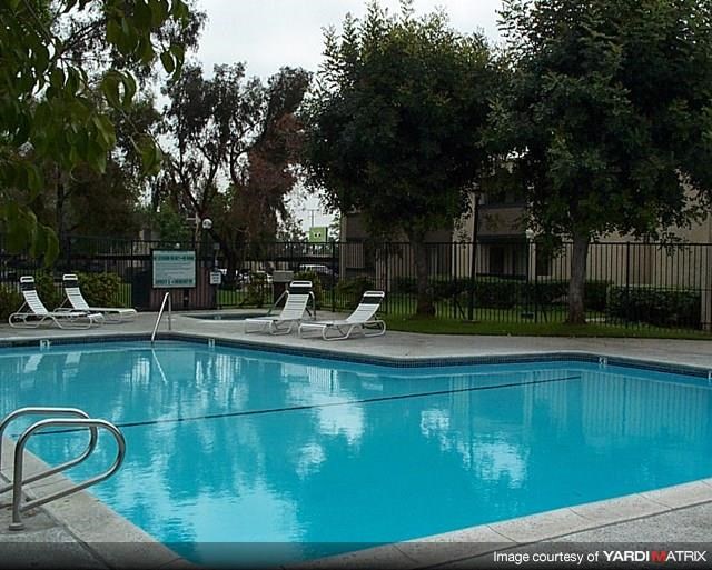 a blue swimming pool with white chairs