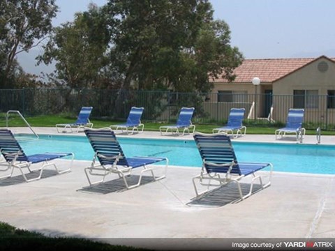 a swimming pool with blue and white chairs