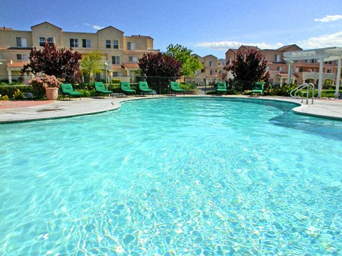 A large swimming pool in front of apartment buildings.