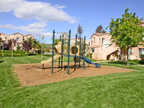 A playground with a slide and a swing set.