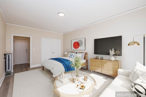 A bedroom with a bed, dresser, and television.