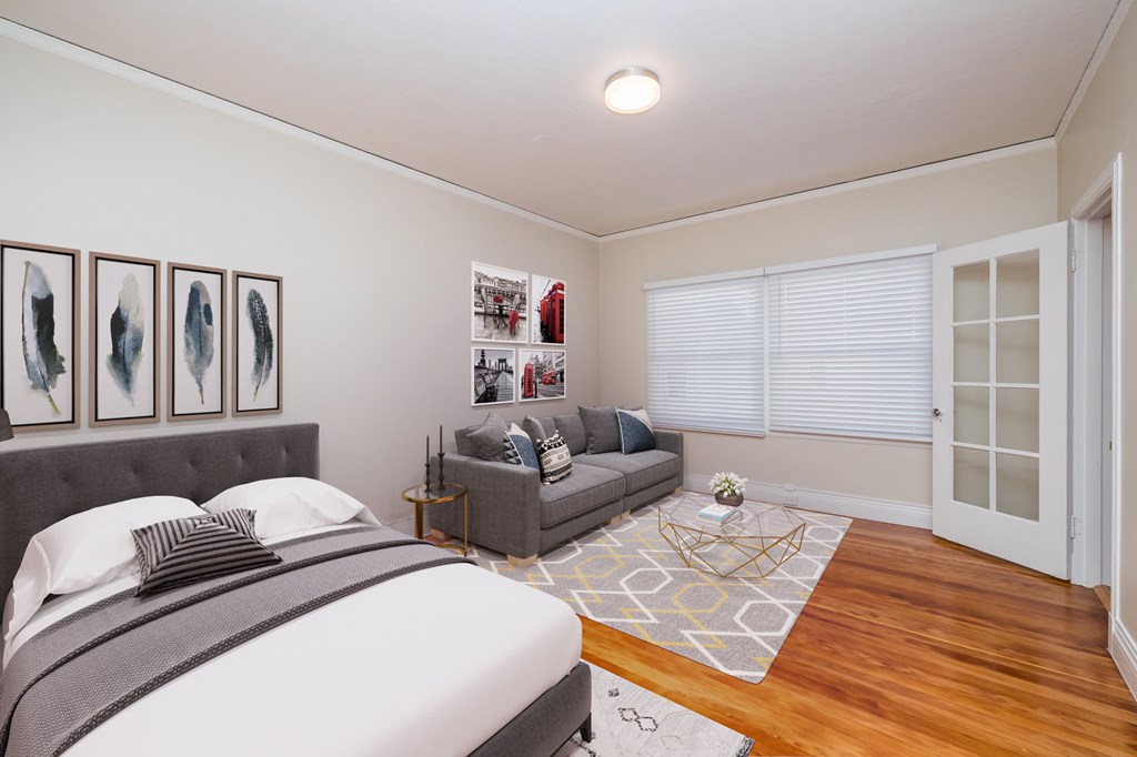 a bedroom with a bed and a couch and a window