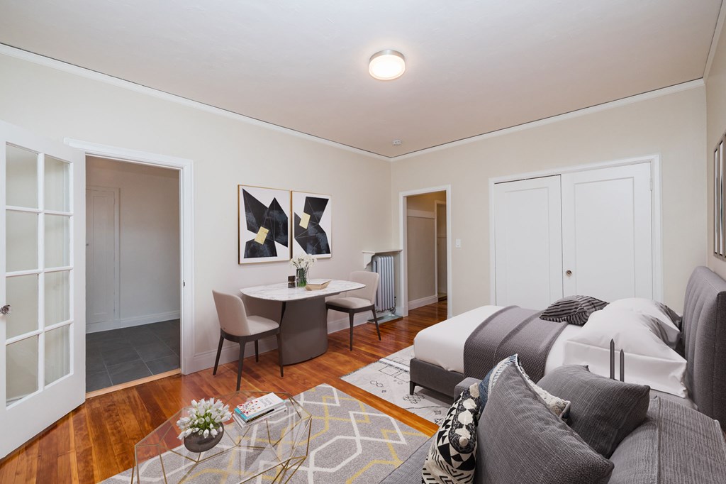 a bedroom with a bed and a desk and a living room