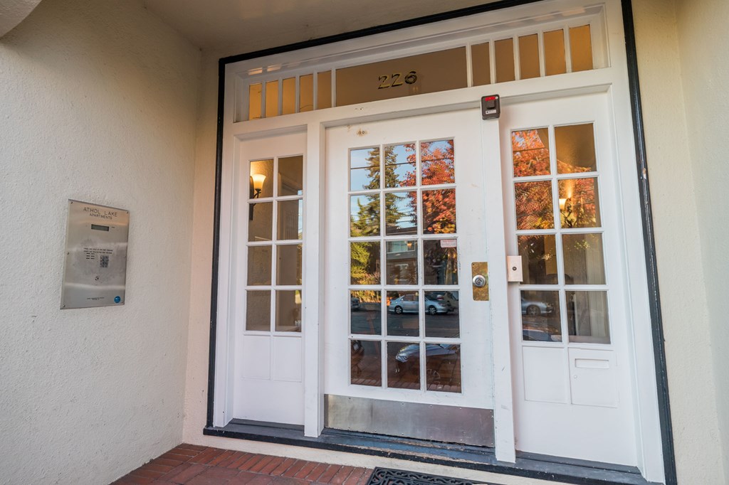 the front door of a building with white doors and windows