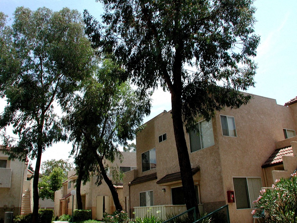 an apartment building with trees in front of it