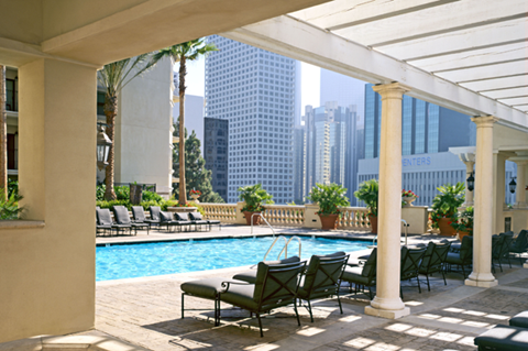 A pool area with chairs and a table with a pool table in the middle.