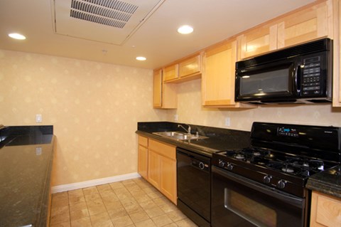 a kitchen with a stove and a microwave and a sink
