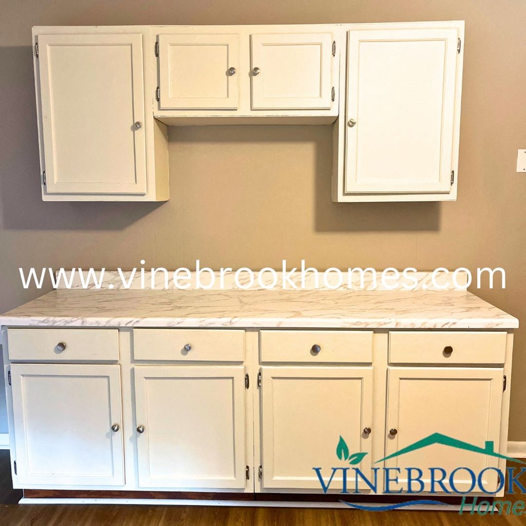 a kitchen with white cabinets and a counter top