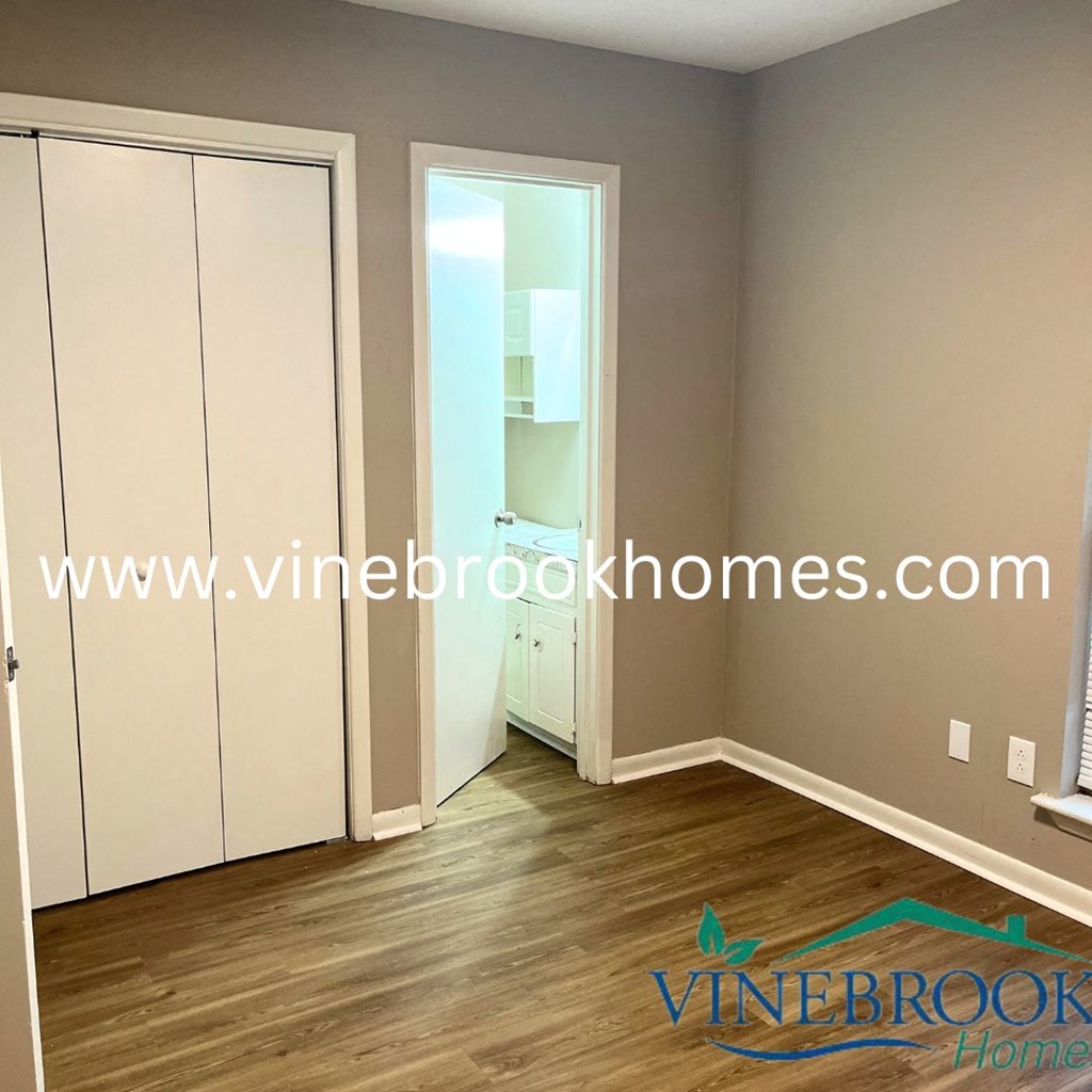 a bedroom with a closet and a door to a bathroom