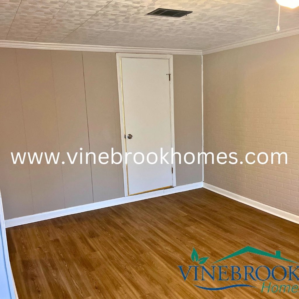 a bedroom with white closets and a wood floor