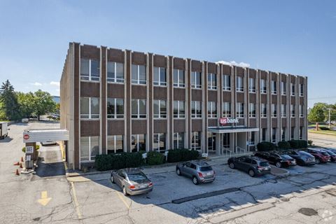 a large brick building with cars parked in a parking lot