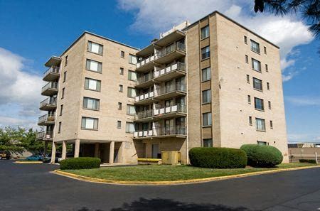 a large apartment building with a grass lawn