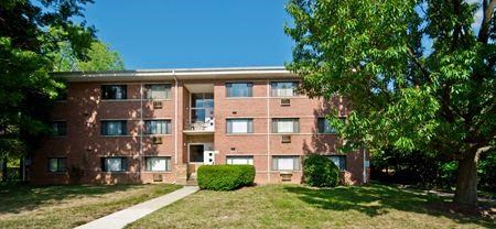 a brick apartment building with grass and trees