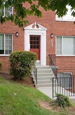 a red brick building with a red door and stairs