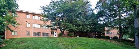 a large brick building with green grass and trees