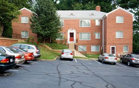 a parking lot with cars in front of a brick building