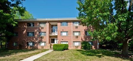 a brick apartment building with grass and trees