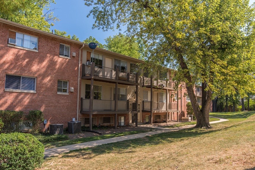 a red brick apartment building with a tree in front of it