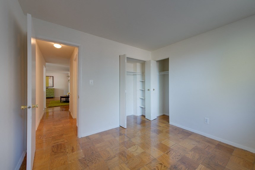 a living room and hallway with wood floors and white walls