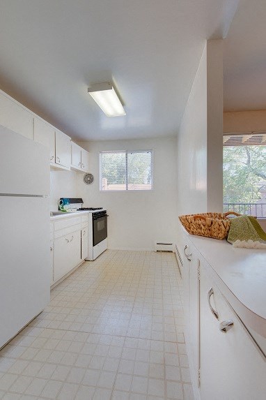 a white kitchen with a sink and a refrigerator