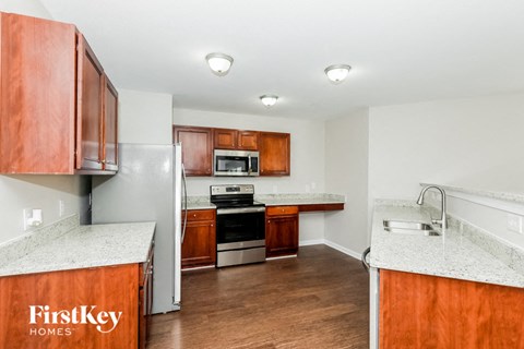A kitchen with wooden cabinets and a refrigerator.