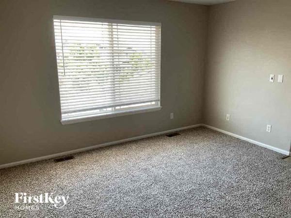 a empty room with a window and carpet