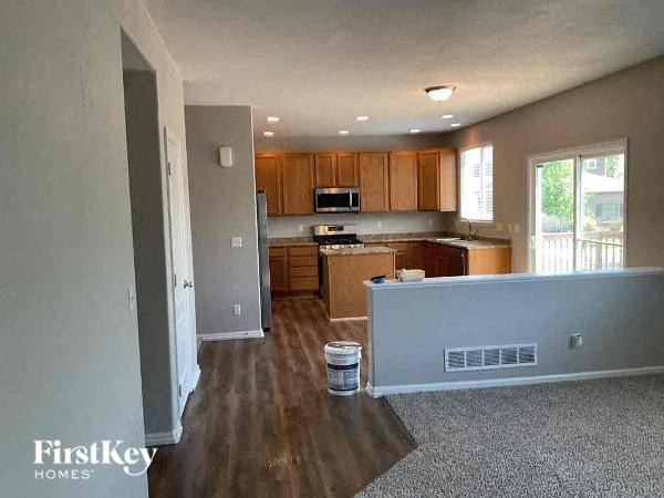 an empty kitchen with wood flooring and