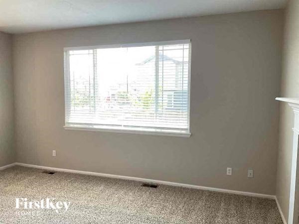an empty room with a window and a carpeted floor